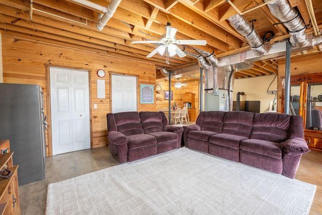 living room with wooden walls, concrete floors, and ceiling fan