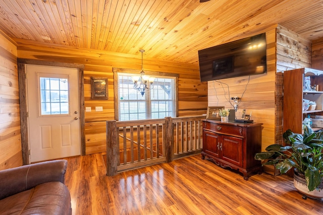 foyer entrance featuring hardwood / wood-style flooring, a healthy amount of sunlight, and wooden walls