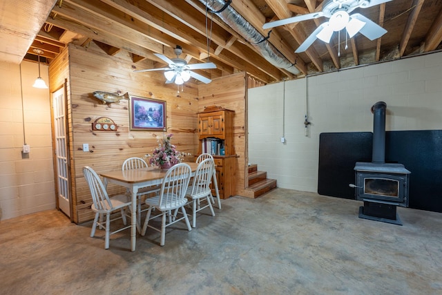 dining space featuring ceiling fan and a wood stove