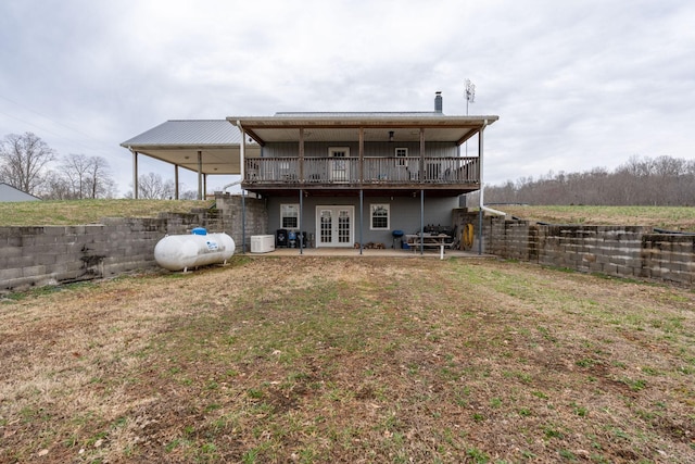 back of property featuring a patio, a wooden deck, a lawn, and french doors