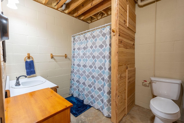 bathroom with toilet, vanity, and concrete flooring