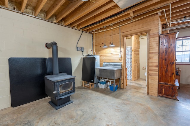 basement featuring sink and a wood stove