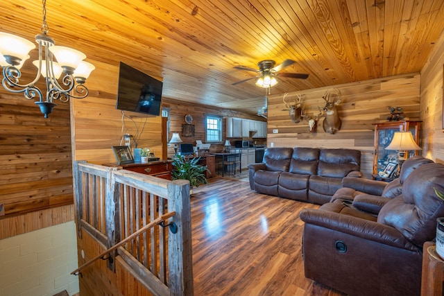 living room with wood ceiling, wood walls, ceiling fan with notable chandelier, and hardwood / wood-style flooring