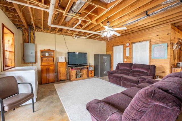 living room featuring ceiling fan, wooden walls, and electric panel