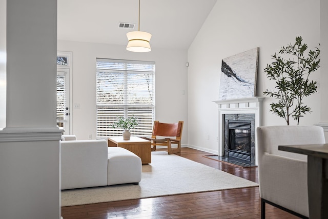 living room with dark wood-type flooring, lofted ceiling, and a fireplace