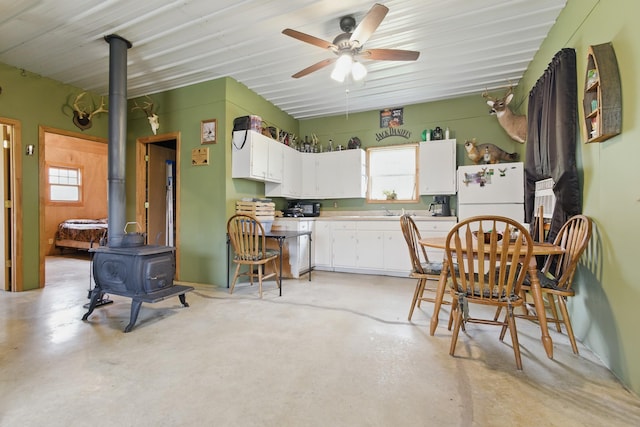 474 Bartlett Hollow Rd, Petersburg, TN 37144 - kitchen featuring a ceiling fan, finished concrete floors, white cabinetry, a wood stove, and freestanding refrigerator