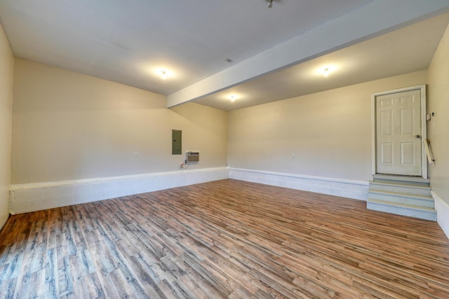 spare room with hardwood / wood-style floors, beam ceiling, and electric panel