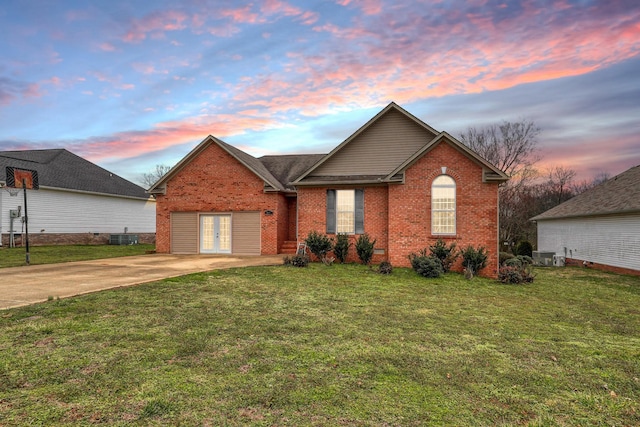 view of front of house with a yard, central AC unit, french doors, and brick siding