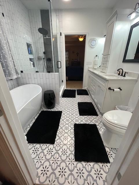 bathroom featuring tile patterned floors, independent shower and bath, and vanity