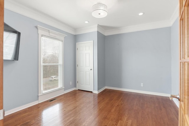 empty room featuring ornamental molding and dark hardwood / wood-style floors