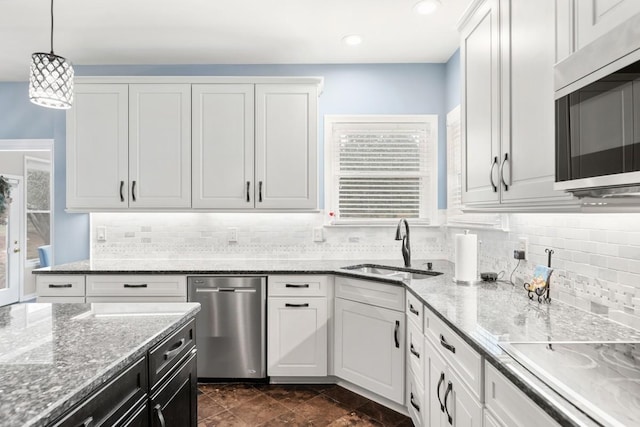 kitchen with sink, stainless steel appliances, hanging light fixtures, and white cabinets