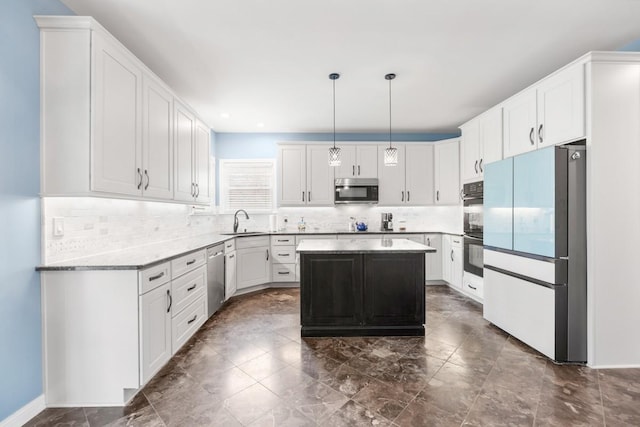 kitchen with pendant lighting, refrigerator, sink, white cabinets, and a center island