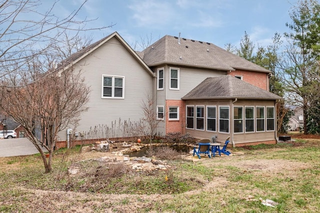 rear view of property featuring a lawn