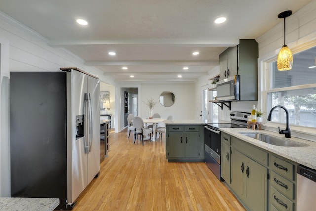 kitchen featuring a wealth of natural light, decorative light fixtures, sink, stainless steel appliances, and light hardwood / wood-style flooring