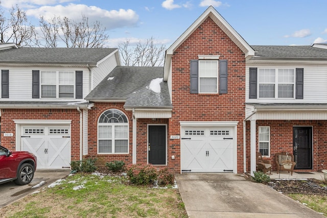 view of front of home featuring a garage, driveway, roof with shingles, and brick siding