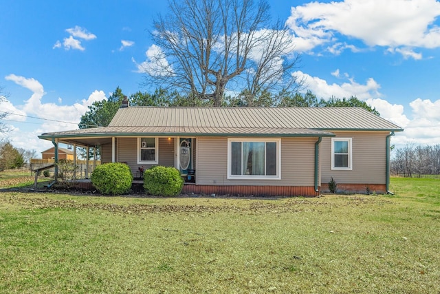 view of front of house featuring metal roof, a chimney, a porch, and a front yard