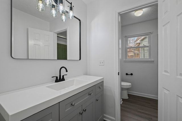 bathroom featuring hardwood / wood-style flooring, vanity, toilet, and a textured ceiling