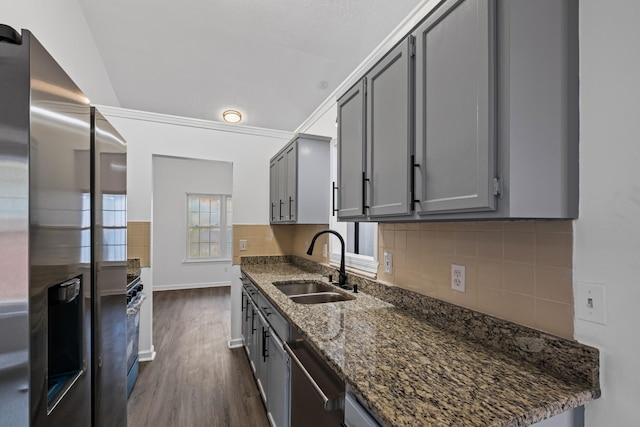 kitchen featuring sink, appliances with stainless steel finishes, dark hardwood / wood-style floors, gray cabinets, and dark stone counters