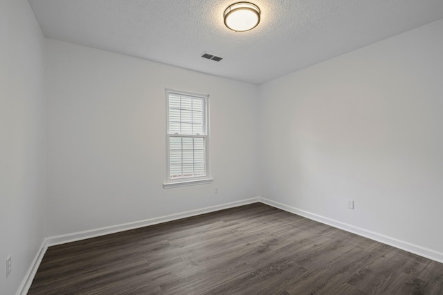 unfurnished room with dark wood-type flooring and a textured ceiling