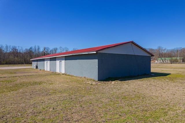 view of home's exterior featuring metal roof, an outbuilding, a lawn, and a pole building