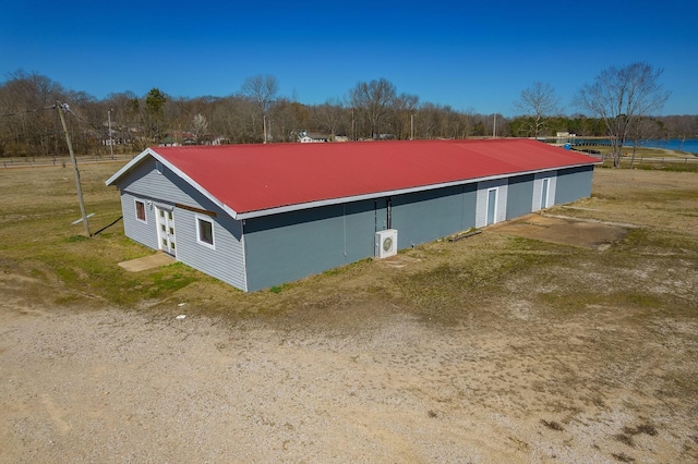 view of side of property featuring metal roof and an outbuilding