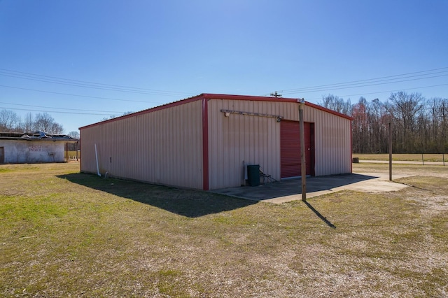 view of pole building featuring driveway and a yard
