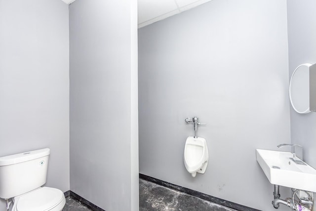 half bath with a sink, baseboards, toilet, and concrete floors