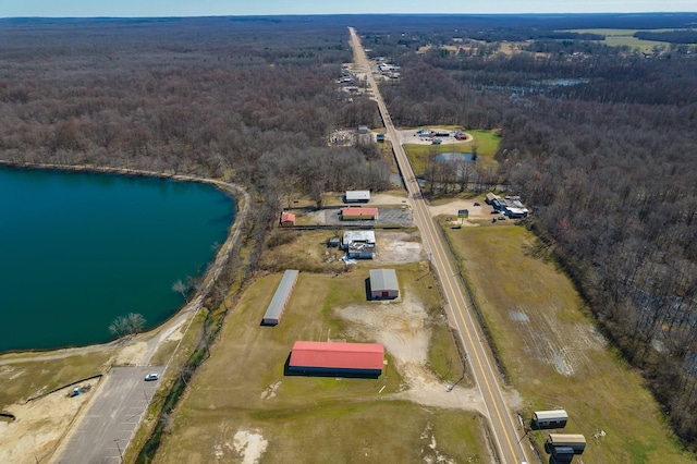 birds eye view of property featuring a forest view and a water view