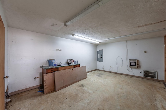 finished below grade area featuring electric panel, baseboards, heating unit, and visible vents