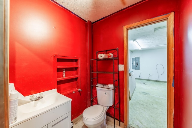 half bathroom featuring toilet, electric panel, a textured ceiling, baseboards, and vanity