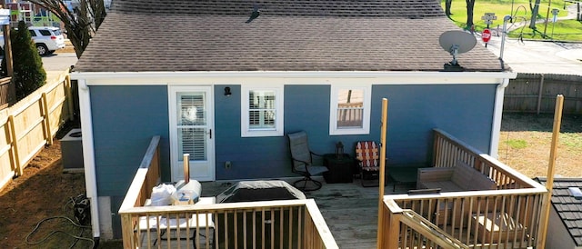 exterior space featuring a shingled roof, fence private yard, and a wooden deck