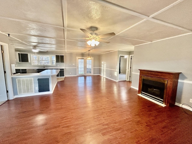 unfurnished living room with wood-type flooring, coffered ceiling, and ceiling fan