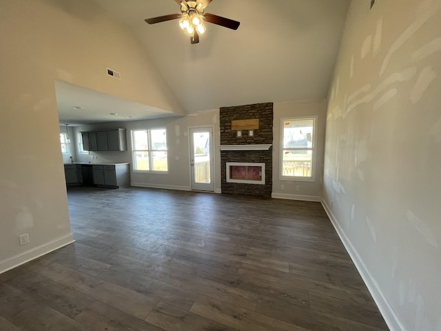 unfurnished living room featuring dark hardwood / wood-style flooring, a fireplace, high vaulted ceiling, and ceiling fan