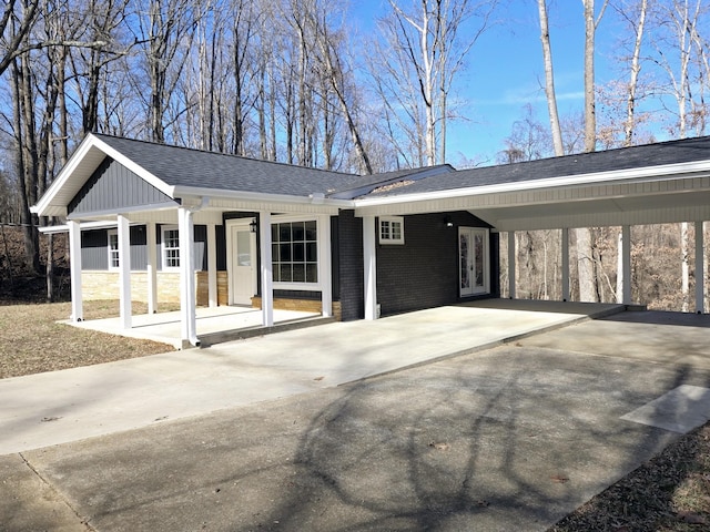 ranch-style home featuring a carport and covered porch