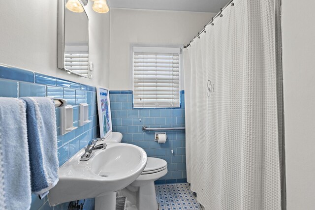 bathroom with tile walls, tile patterned floors, toilet, and walk in shower