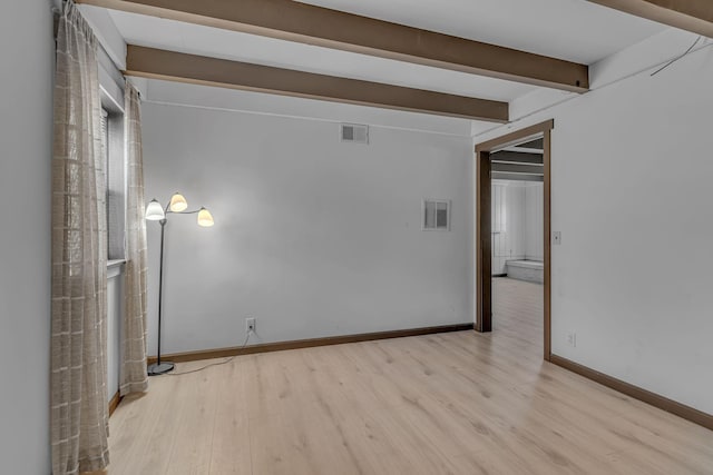 empty room with beam ceiling and light hardwood / wood-style floors