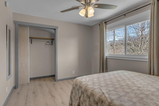 bedroom with light hardwood / wood-style floors, a closet, and ceiling fan