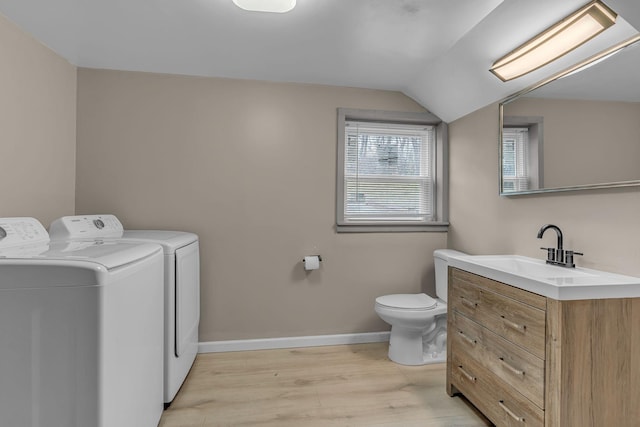 laundry area featuring washer and dryer, sink, and light wood-type flooring