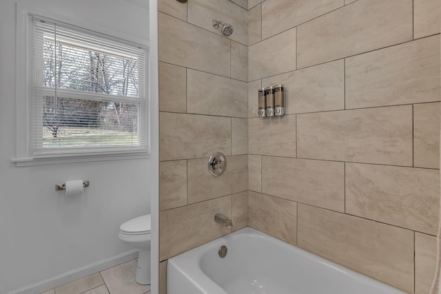 bathroom featuring tiled shower / bath, tile patterned floors, and toilet