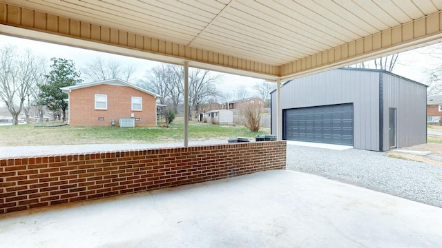 view of patio / terrace with a garage, central AC unit, and an outdoor structure