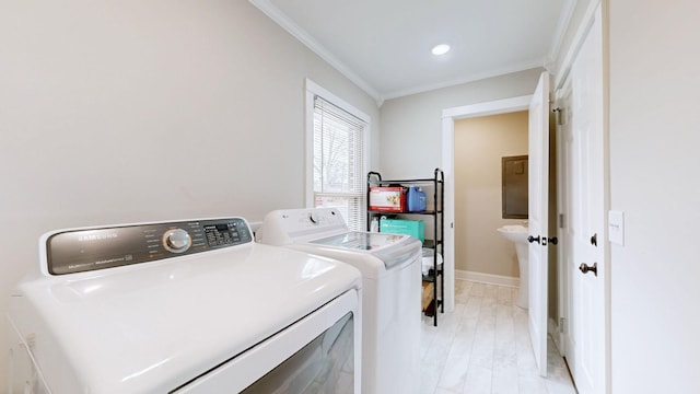 clothes washing area with light wood finished floors, washing machine and clothes dryer, ornamental molding, laundry area, and baseboards