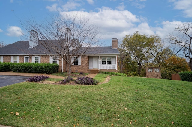 view of front of home with brick siding, crawl space, a front yard, and a chimney