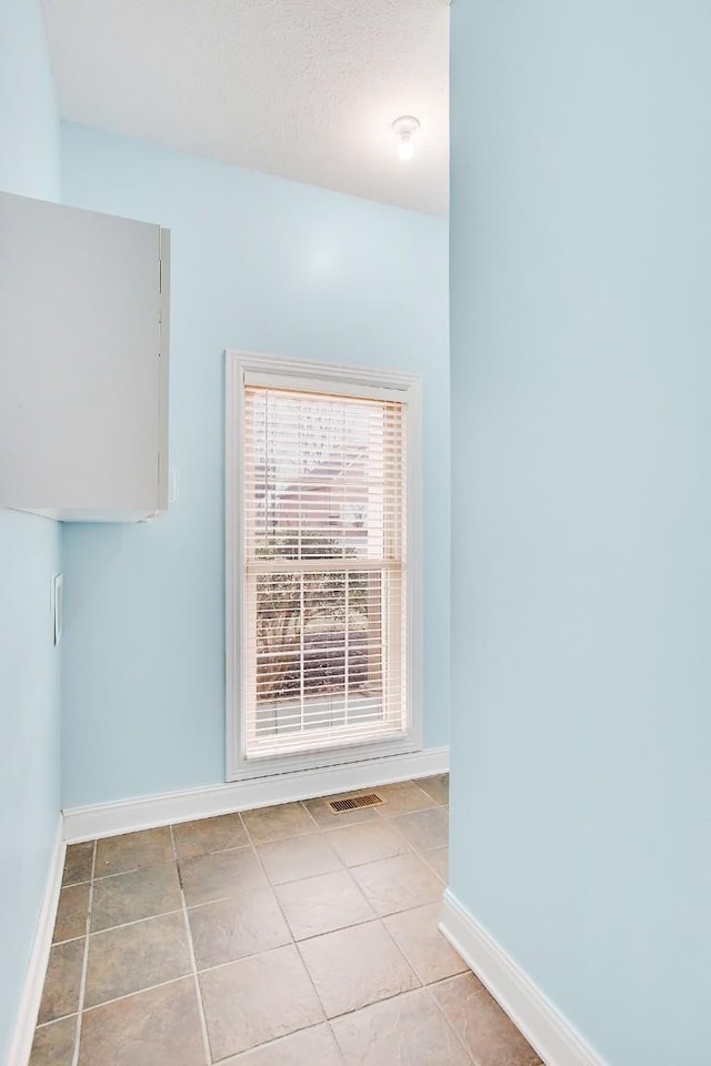unfurnished room featuring light tile patterned floors and baseboards