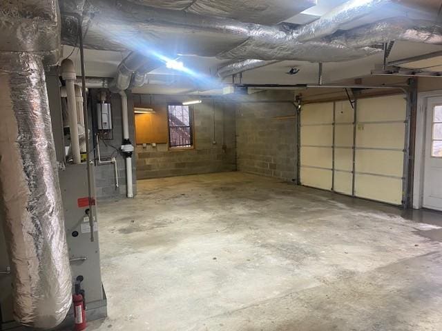 garage with heating unit and concrete block wall