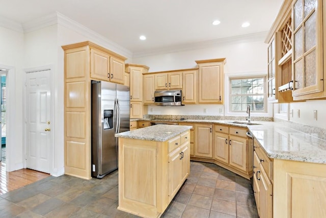 kitchen with a sink, light brown cabinets, light stone countertops, and stainless steel appliances