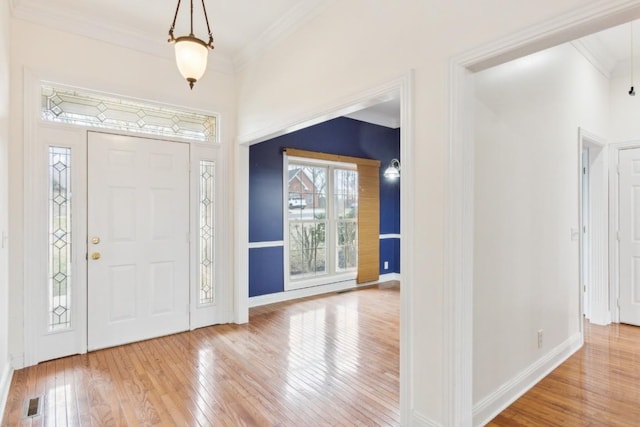 entrance foyer featuring baseboards, hardwood / wood-style floors, and ornamental molding