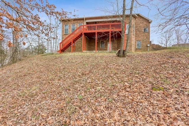 back of property featuring a deck and stairs