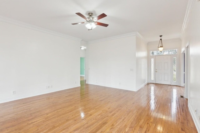 unfurnished living room with baseboards, a ceiling fan, light wood-style floors, and ornamental molding