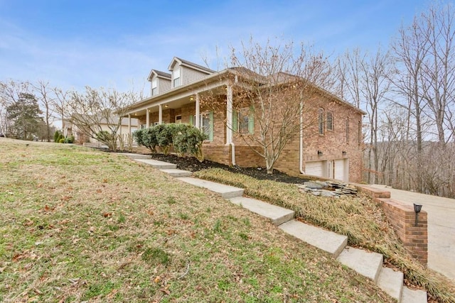 view of property exterior with a garage, a lawn, and covered porch