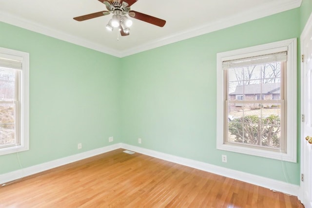 unfurnished room with a ceiling fan, light wood-style floors, baseboards, and ornamental molding